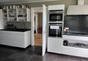 a kitchen with white cabinets and a stove top oven at Sölje Herrgård Annexet in Glava