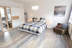 a bedroom with a bed and a chair at Fewo Am Rathaus - ABC351 in Wismar