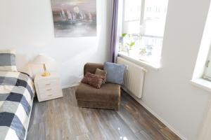 a bedroom with a chair and a bed and a window at Fewo Am Rathaus - ABC351 in Wismar