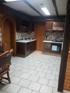 a kitchen with brown cabinets and a white tile floor at Wacholderweg 10,Hans Hyzak in Düsseldorf