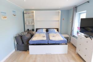 un dormitorio con una cama y un sofá en FeWo Thule Poel an der Ostsee - ABC368 - nur Feriengäste!, en Kirchdorf