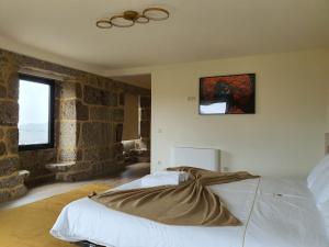 Un dormitorio con una cama y un cuadro en la pared. en Botica House, en Póvoa de Lanhoso 26 fotos más