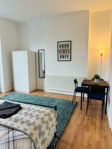 1 dormitorio con cama, mesa y escritorio en Jubilee Rooms 15 Minutes Central London en Londres
