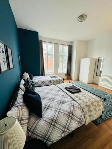 a bedroom with two beds and a large window at Jubilee Rooms 15 Minutes Central London in London