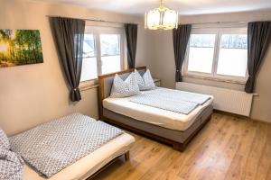 dwa łóżka w pokoju z dwoma oknami w obiekcie Real Top 1 w mieście Keutschach am See