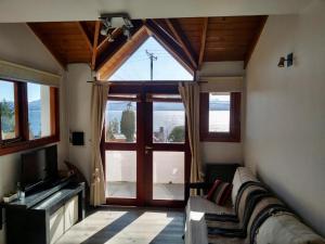 a living room with a couch and a large window at Miralago I in San Carlos de Bariloche +20 photos