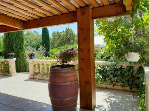a barrel under a wooden pergola with flowers at Maison de vacances dans le verdon in Saint-Julien