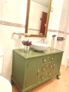 Un baño con una cómoda verde con lavabo y espejo. en Casa Hijuela, en Concejero 27 fotos más