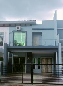 uma casa azul com uma varanda em Idaman Bayu Homestay 4 Bedrooms by DKAY in Sendayan em Seremban