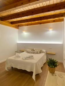 a bedroom with a white bed in a room with wooden ceilings at La espiga de Segovia 2 in La Lastrilla