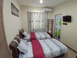 Postel nebo postele na pokoji v ubytování Kota Kinabalu Four Seasons Homestay 沙巴亚庇四季小屋