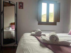 a bedroom with towels on a bed with a mirror at Rascacielos San Martín in Cuenca
