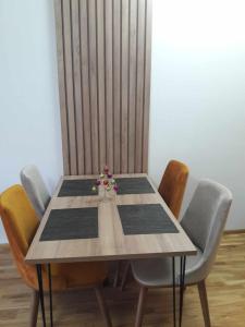 a dining room table with chairs and a table with flowers on it at APARTMANS AJAN OHRID in Ohrid