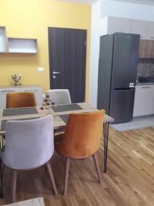 a kitchen with a table and chairs and a refrigerator at APARTMANS AJAN OHRID in Ohrid