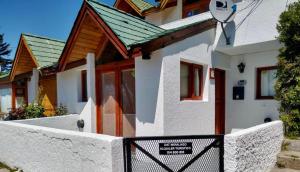 a white house with a gate in front of it at Miralago I in San Carlos de Bariloche