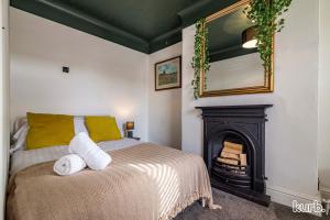 een slaapkamer met een bed, een open haard en een spiegel bij Carlton Hill House - 5 Bedroom House with Parking in Nottingham