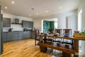 cocina y comedor con mesa de madera en Carlton Hill House - 5 Bedroom House with Parking, en Nottingham