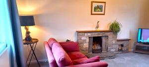 sala de estar con sofá y chimenea en Little Harries Cottage - surrounded by open fields, en Ripon