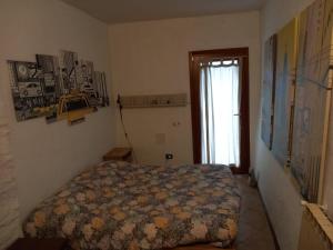 ein Schlafzimmer mit einem Bett in einem Zimmer mit einem Fenster in der Unterkunft Casa di sotto in Giratola