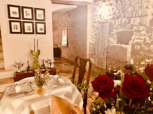 斯波萊托的住宿－Palazzo Sant'Angelo，一间用餐室,配有一张红玫瑰桌