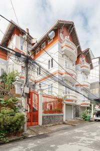 ein orange-weißes Gebäude mit einem orangefarbenen Tor in der Unterkunft Villa De Pastry Vesta Collections in Ho-Chi-Minh-Stadt