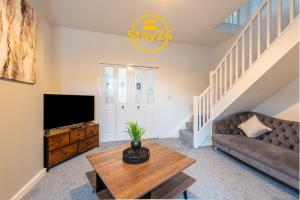 a living room with a couch and a television at Elizabeth Place in Crewe