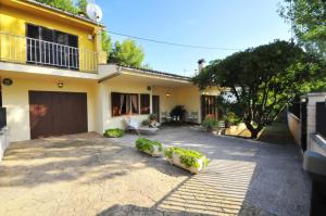 a large yellow house with a driveway at Cora in Port d'Alcudia