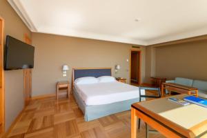 a bedroom with a bed and a table and a tv at Hotel Royal Continental in Naples