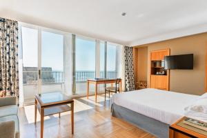 a hotel room with a bed and a large window at Hotel Royal Continental in Naples