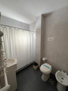 a white bathroom with a toilet and a sink at La Cibeles in Miramar