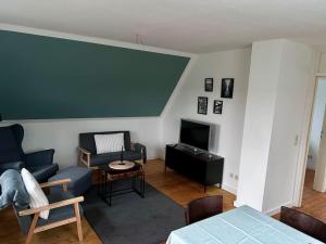 a living room with a blue couch and a tv at Ferienhaus am Poggensee in Bad Oldesloe
