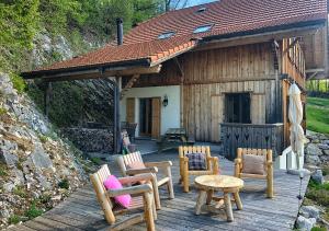 a wooden deck with chairs and tables and a building at Chalet authentique avec magnifique vue in Cerniat