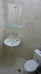 a bathroom with a sink and a toilet and a mirror at Намира се под връх Исполин,на 5км от Шипка,има 300м ски писта със Чайна и ски гардероб+детски шейни,паркинг, Леглова база-35 места разпределени в 11 стаи,всички стаи са със самостоятелна баня и тоалетна. 