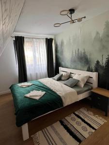 a bedroom with a large bed with a green blanket at Mokki in Mărişel
