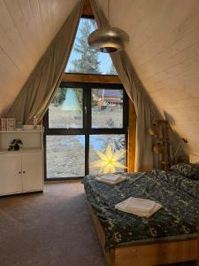 a bedroom with a bed and a large window at Mokki in Mărişel