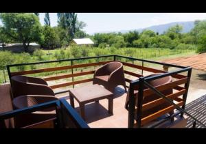 a balcony with chairs and a table and a fence at Cabañas Del Rio in San Francisco del Monte de Oro +7 photos