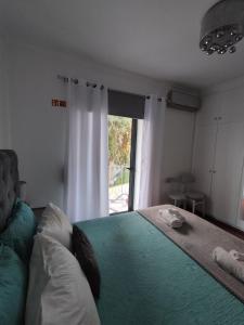 een slaapkamer met een groot groen bed en een raam bij Alexia Room in Funchal