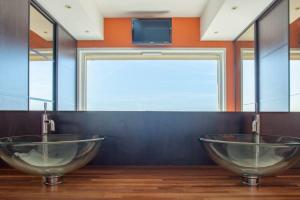 La salle de bains est pourvue de 2 lavabos et d'une télévision murale. dans l'établissement Appartement spacieux - Vue mer panoramique, à Villefranche-sur-Mer