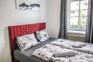 1 Schlafzimmer mit 2 Betten und einem roten Kopfteil in der Unterkunft Cozy Rooms in Pragerstrasse in Wien