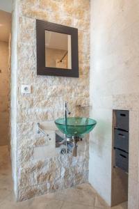 La salle de bains est pourvue d'un lavabo vert et d'un miroir. dans l'établissement Appartement spacieux - Vue mer panoramique, à Villefranche-sur-Mer