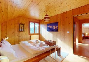 een slaapkamer met een bed in een houten hut bij Chalet authentique avec magnifique vue in Cerniat