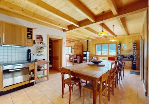 cocina y comedor con mesa de madera y sillas en Chalet authentique avec magnifique vue en Cerniat