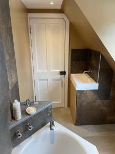 a bathroom with a sink and a bath tub at Braemorriston Lodge in Elgin