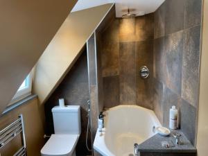 a bathroom with a toilet and a bath tub at Braemorriston Lodge in Elgin