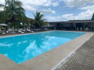 a pool with palm trees and a building at Hotel Turístico de Alagoinhas in Alagoinhas