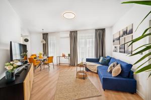 ein Wohnzimmer mit einem blauen Sofa und einem Tisch in der Unterkunft Smart Home - Gloria Apartment by Avenue in Timişoara