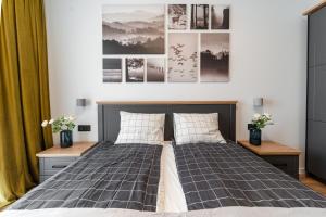 a bedroom with a bed and some pictures on the wall at Smart Home - Gloria Apartment Avenue - By OpenHouse in Timişoara