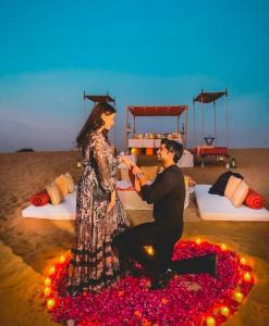 un hombre y una mujer sentados en un círculo de flores en Luxury The Sunrise Resort with swimming pool Jaisalmer, en Jaisalmer