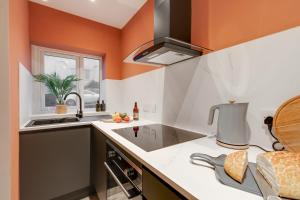 een keuken met oranje muren en een wastafel bij Beach Apartment - 2 Bedrooms Free WiFi Parking in Cleveleys