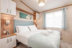 Un dormitorio con una cama grande y una ventana en Maison Verte Lodge 8 Close to St Andrews en Strathkinness